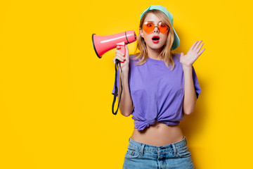 Young style girl in purple clothes with pink megaphone on yellow background. Symbolizes female...