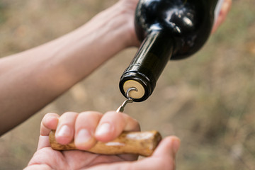 Man opens a bottle of wine corkscrew old