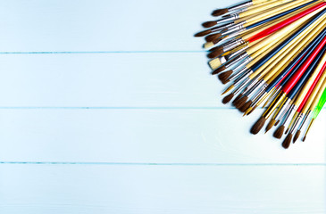 Paint brushes and paint on an background.