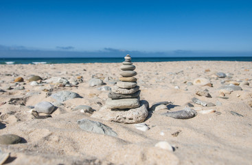 Fototapeta na wymiar pyramid of flat stones on the ocean