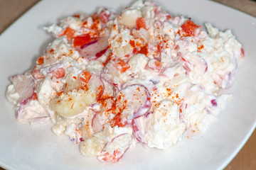 Cauliflower Smash a potato salad substitute that is low carb and good for those on the Keto Diet. Made of Cauliflower, radishes, sweet onions and red peppers with a sprinkle of paprika.