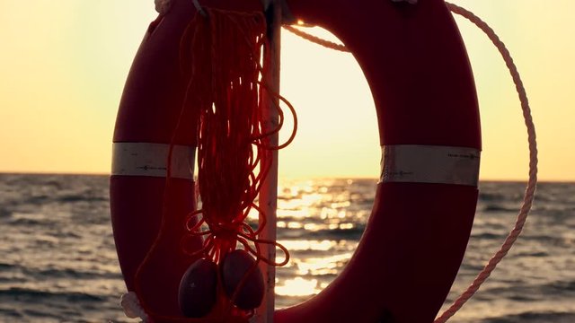Orange circles of safety on a sea beach in the rays of the setting sun. Slow Motion Picture