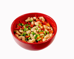 Navy beans and bell peppers in red bowl isolated on white