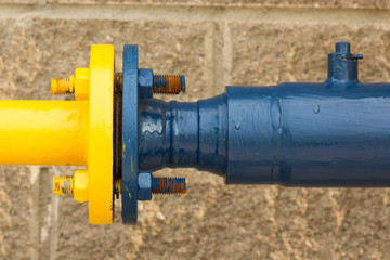 Connection of blue-and-yellow gas pipe, close-up from the street side