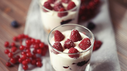 Happy breakfast - yogurt with muesli and berries on a wooden table