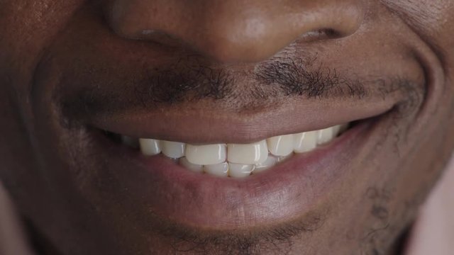 close up african american man lips smiling cheerful happy showing healthy white teeth dental health concept