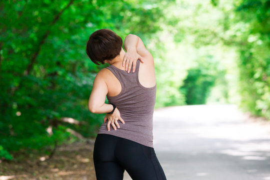Woman with back pain, injury while running, trauma during workout