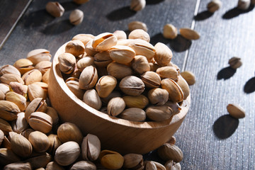 Composition with bowl of pistachio on wooden table. Delicacies