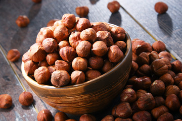 Bowl with hazelnuts on wooden table.