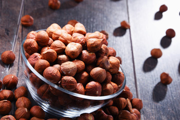 Bowl with hazelnuts on wooden table.