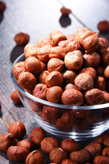 Bowl with hazelnuts on wooden table.