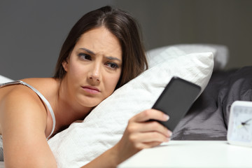 Nervous woman checking phone in the night