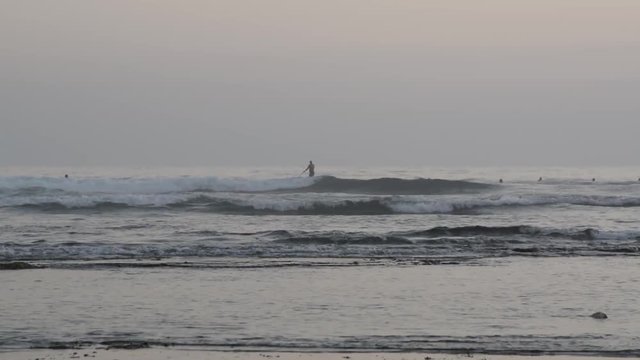 surfers in the water in Ribeira de Ilhas beach in Ericeira