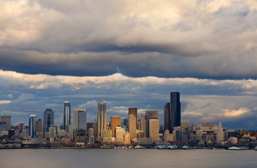 Naklejka premium Seattle Skyline After A Rain Squall. Dramatic clouds surround the city of Seattle and the vibrant waterfront with modern skyscrapers looming large in the background.