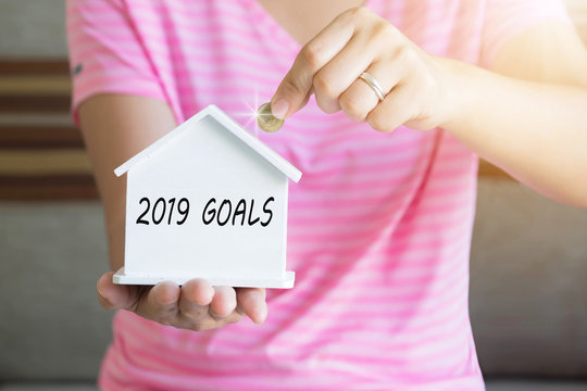 2019 Goals With Women Hand Putting Money Coin In Piggy Bank, Saving Money Concept, Concept Of Financial Savings To Buy A House, Growth, Business, Money.