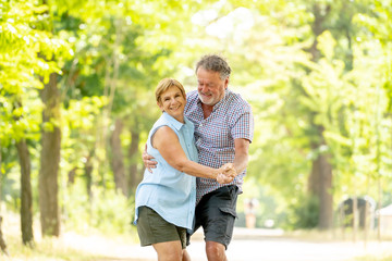 Happy smiling senior couple in love, dancing and having fun in the park. Being together, in love, retirement happy life concept.