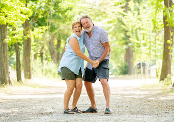 Obraz premium Happy smiling senior couple in love, dancing and having fun in the park. Being together, in love, retirement happy life concept.