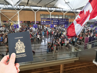 Hand handing Canadian passport at Canadian airport custom counters, returning home concept