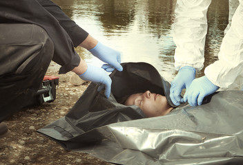 Woman found drowned on river bank in city placed in body bag for transportration