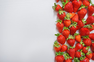 strawberry fruits on the right side on wooden background with copy space. View from above.