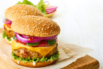 Two delicious cheeseburgers on wooden board