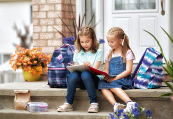 Girls with backpacks near building outdoors.