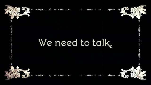 A re-created film frame from the silent movies era, showing an intertitle text: we need to talk.
