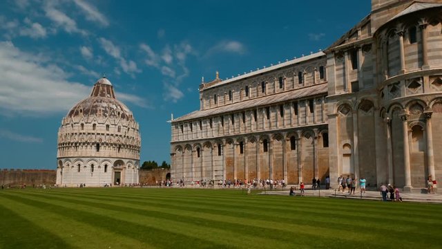 Wide shot of the Baptistery of St. John - Battistero di San Giovanni - and the Pisa Cathedral in the Piazza dei Miracoli, Italy. Pisa has more than 20 historic churches and several medieval palaces