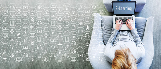 E-Learning concept with man using a laptop in a modern gray chair