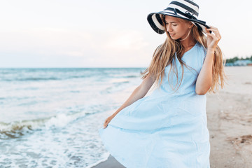 Beautiful portrait of a girl in a hat close-up, rest on the sea or ocean, a woman in a summer dress