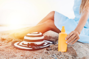 girl resting on the beach, beautiful tanned legs against the blue sea, jar of cream