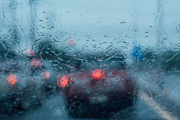 Road view through car windshield with rain drops, Driving in rain.
