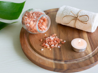 Pink Himalayan salt and towel on wooden plank