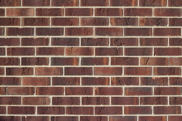 Traditional running bond pattern brown brick wall background with rust color striations
