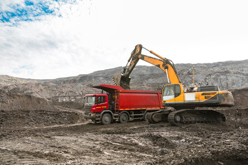 Large quarry dump truck. Loading the rock in dumper. Loading coal into body truck. Production useful minerals. Mining truck mining machinery, to transport coal from open-pit as the coal production.