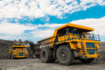 Large quarry dump truck. Loading the rock in dumper. Loading coal into body truck. Production useful minerals. Mining truck mining machinery, to transport coal from open-pit as the coal production.