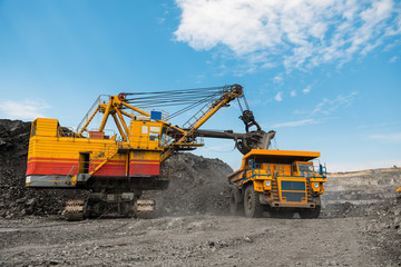 Large quarry dump truck. Loading the rock in dumper. Loading coal into body truck. Production useful minerals. Mining truck mining machinery, to transport coal from open-pit as the coal production.