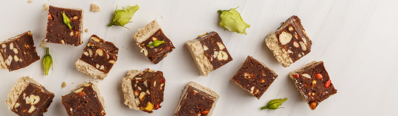 Raw vegan slices with nuts and cocoa on white background, top view. Healthy vegan food concept.