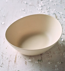 Empty clean beige oval bowl on rustic white wood