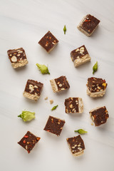 Raw vegan slices with nuts and cocoa on white background, top view. Healthy vegan food concept.
