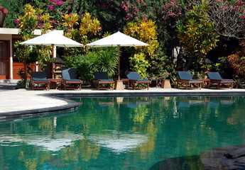 Hotel swimming pool , with sunbeds under umbrellas around