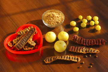 Gooseberries, powder, star gooseberries and shikakai or Acacia concinna seeds isolated on brown background