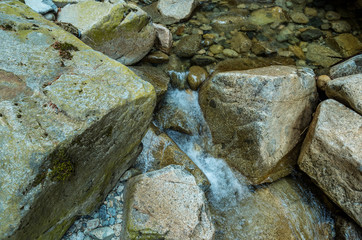 clear water running down the crack among the big rocks in the creek.