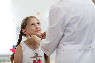 Little child girl looking at doctor who testing her tonsils