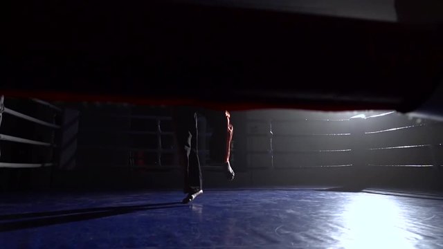 Man trains in the ring . Silhouette. Light from behind