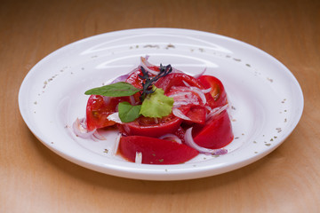 A bowl of light summer salad of tomato and onion