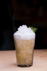 Cool lemonade in glass on wooden table in Summer