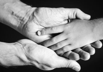black and white photo of a father holding his son's hand
