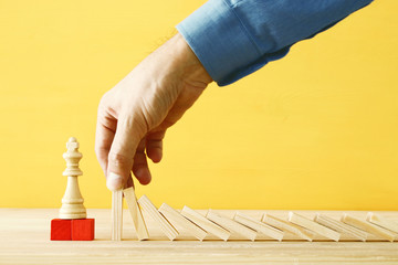 image of male hand stopping the domino effect. executive and risk control concept.