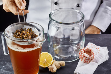 Man preparing kombucha tea in jar
